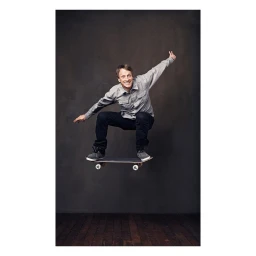 Tony Hawk mid-air on a skateboard in a studio portrait by photographer Sam Jones