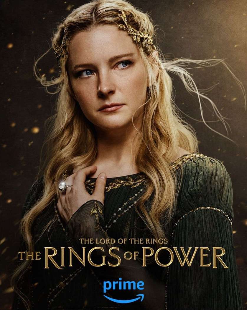 Portrait of a light-skinned woman with long blonde hair and a jeweled headband, wearing a green dress with gold trim, movie poster.