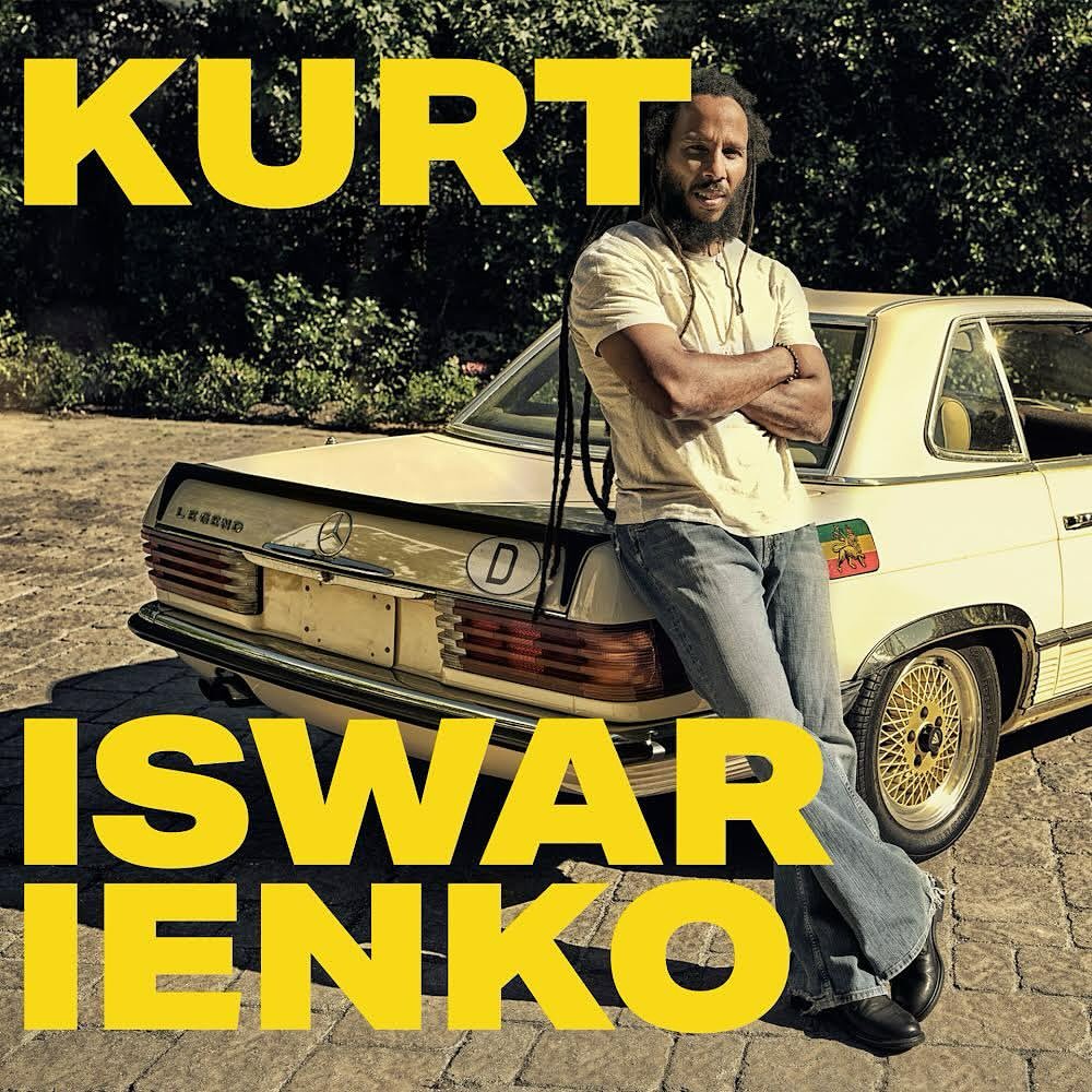 Adult male stands with arms crossed next to a vintage cream-colored Mercedes Benz in an outdoor setting with bright yellow text.