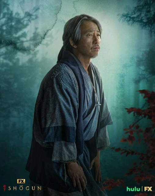 Portrait of Hiroyuki Sanada as Lord Yoshii Toranaga from FX's Shōgun, in a traditional robe, standing outdoors in a misty forest.