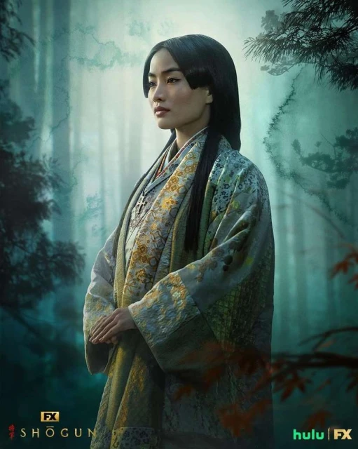 Portrait of Anna Sawai as Lady Mariko in 'Shōgun' series. She wears a floral kimono in a forest with a somber, reflective expression.