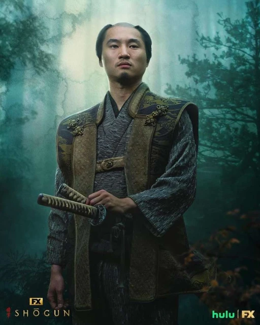 Promotional image of actor Hiroyuki Sanada as Yoshii Toranaga in FX's Shōgun, wearing a traditional kimono and holding two swords in a forest setting.