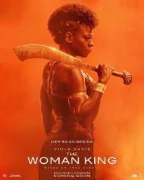 Viola Davis holding a machete across her shoulders in a dramatic promotional portrait against an orange dusty backdrop