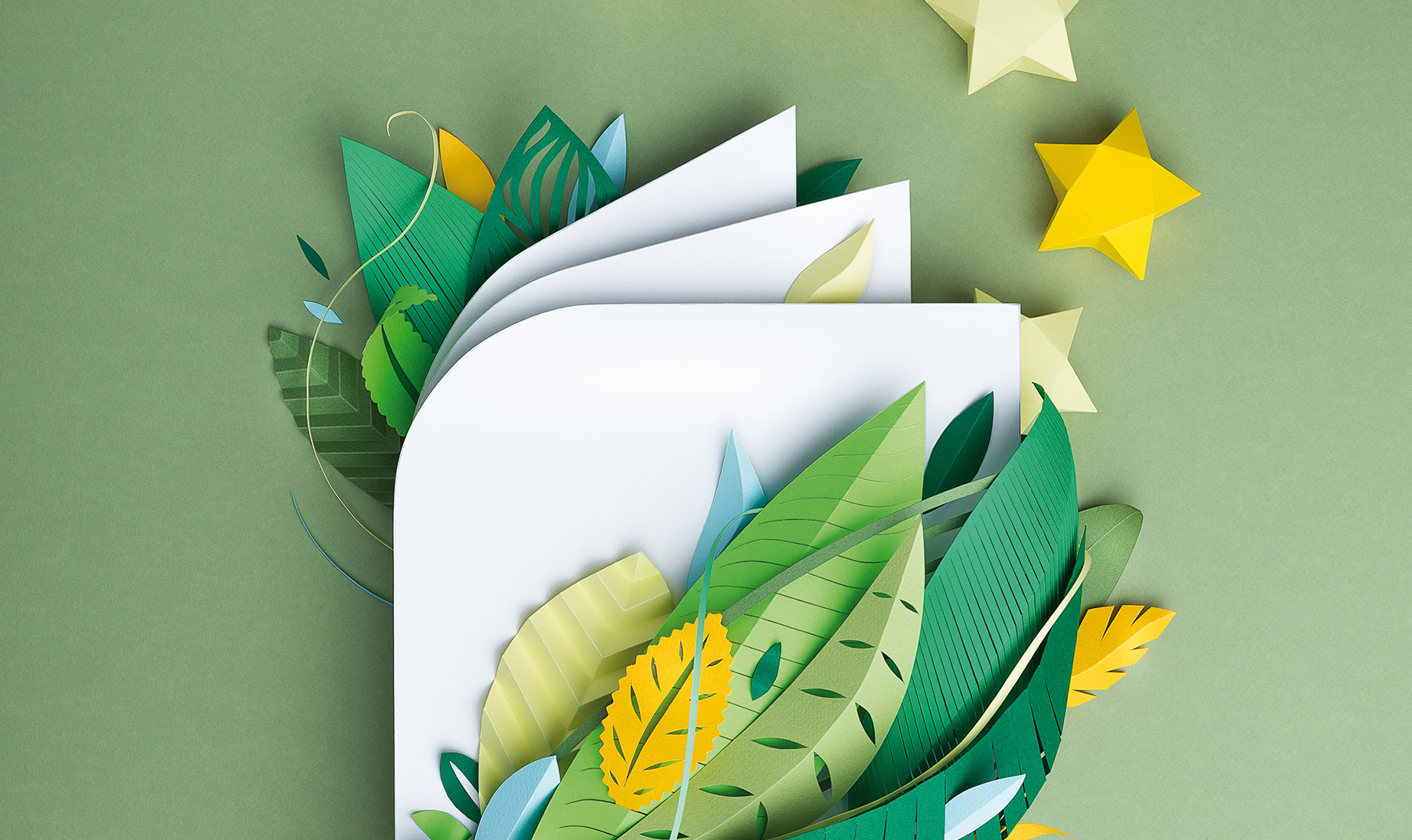 Paper art book with green leaves and yellow stars. Artistic book cover with green and yellow leaves on green background.