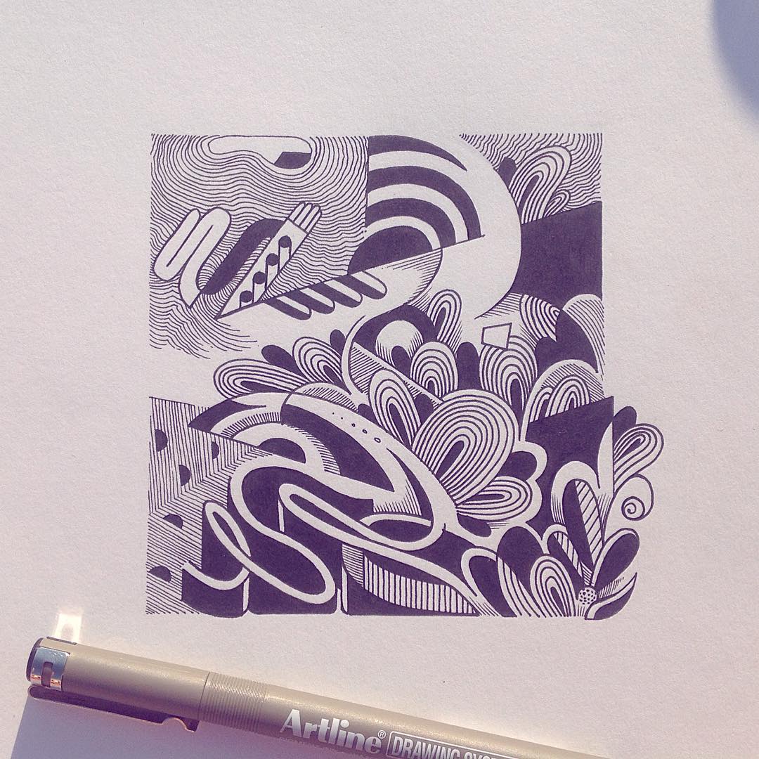 Detailed pen-and-ink drawing features abstract patterns and shapes on white paper with pen in foreground, emphasizing line work.