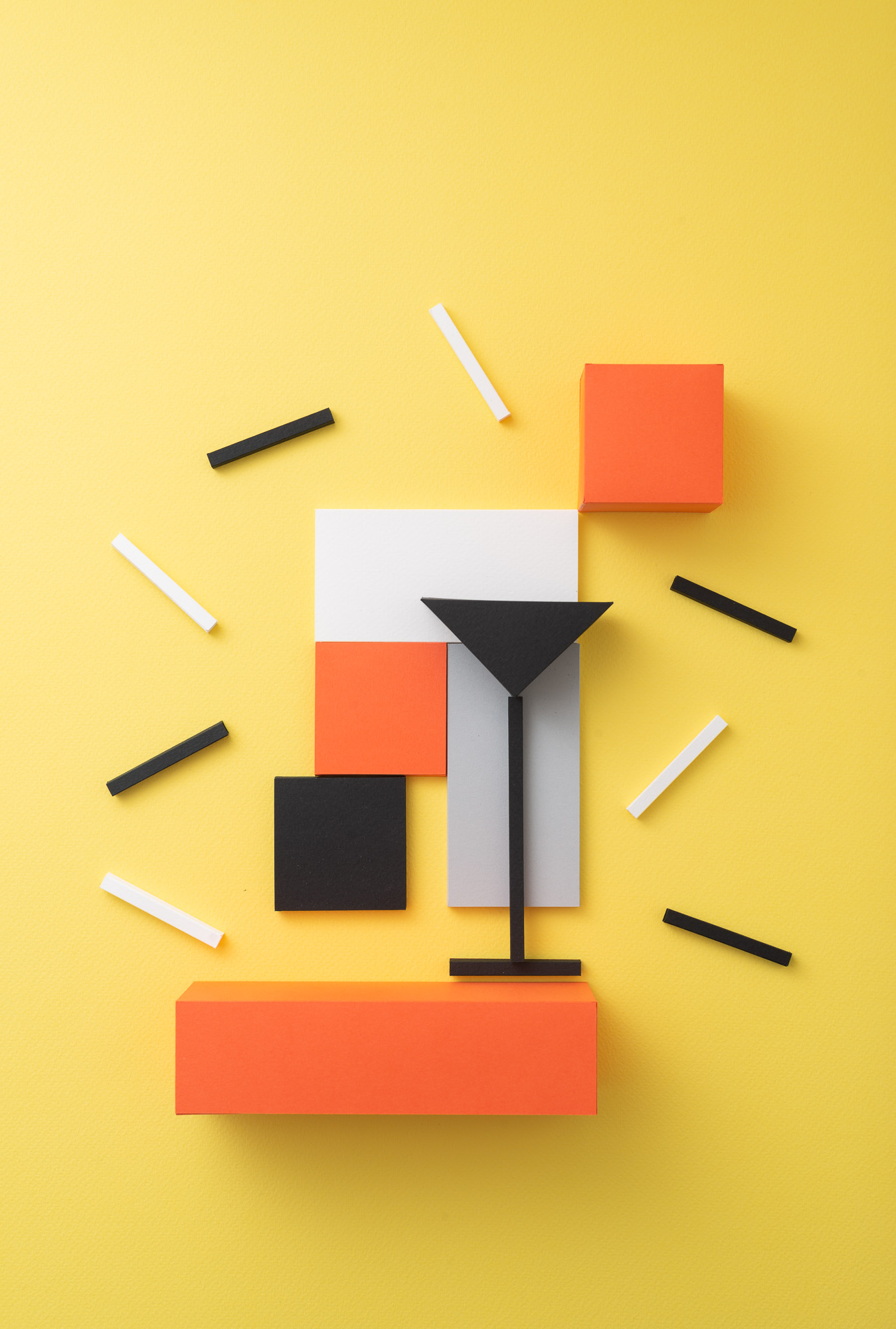 Abstract still life with geometric shapes in black, orange, white, and grey on a yellow background, creating a minimalist composition.
