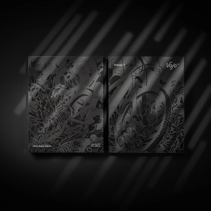 Monochrome black illustrated magazine cover spread for Vojo Volume 3 illuminated by diagonal slatted shadow patterns on a dark surface.