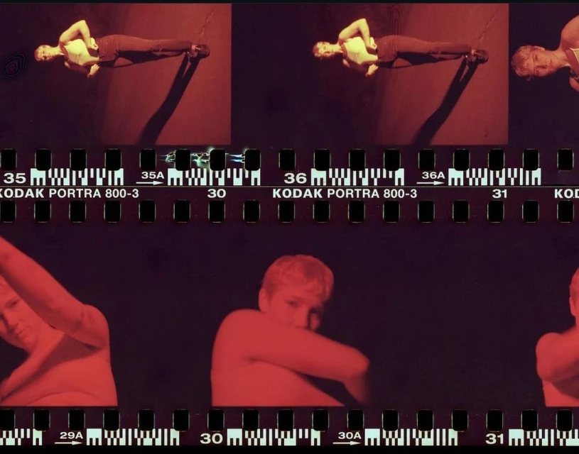 Film strip with a woman posing in several frames in a red tinted environment. The film strip includes KODAK PORTRA 800-3 markings.