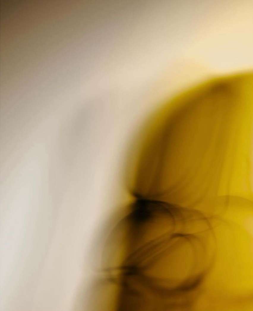 Abstract motion blur with shades of yellow, brown, and beige. The colors blend seamlessly, creating a sense of movement and fluidity.