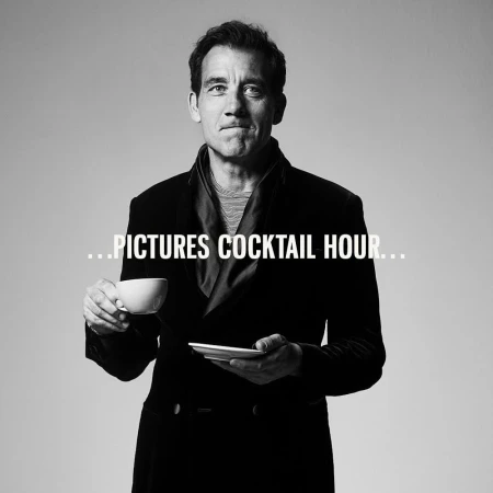 Black and white portrait of Clive Owen holding a teacup and saucer in a dark coat, against a light background.