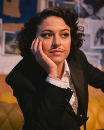Portrait of a woman wearing a black suit jacket and white shirt with a painted-on pencil mustache by photographer Erica Hernandez