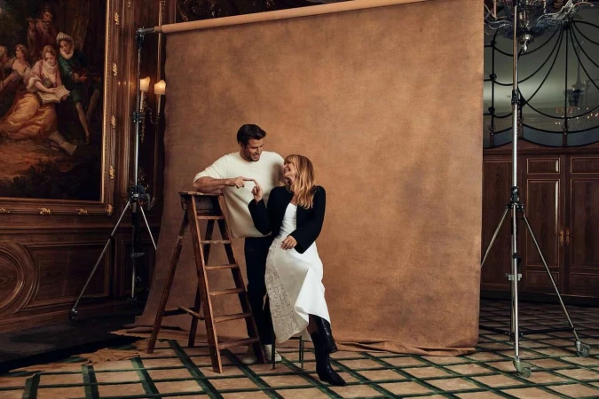 Man and woman smiling in a studio with a brown backdrop, photographed by Leigh Keily