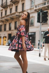 Woman in floral off-shoulder dress posing on a city street by Mihael Vuzem