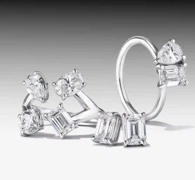 Diamond cluster and open-band rings set in white gold or platinum displayed on a gradient grey studio surface.