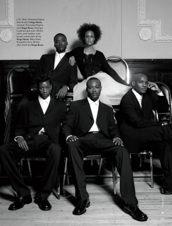 Monochrome fashion shoot featuring a group of four men and a woman wearing formal black suits and dress sitting on chairs.