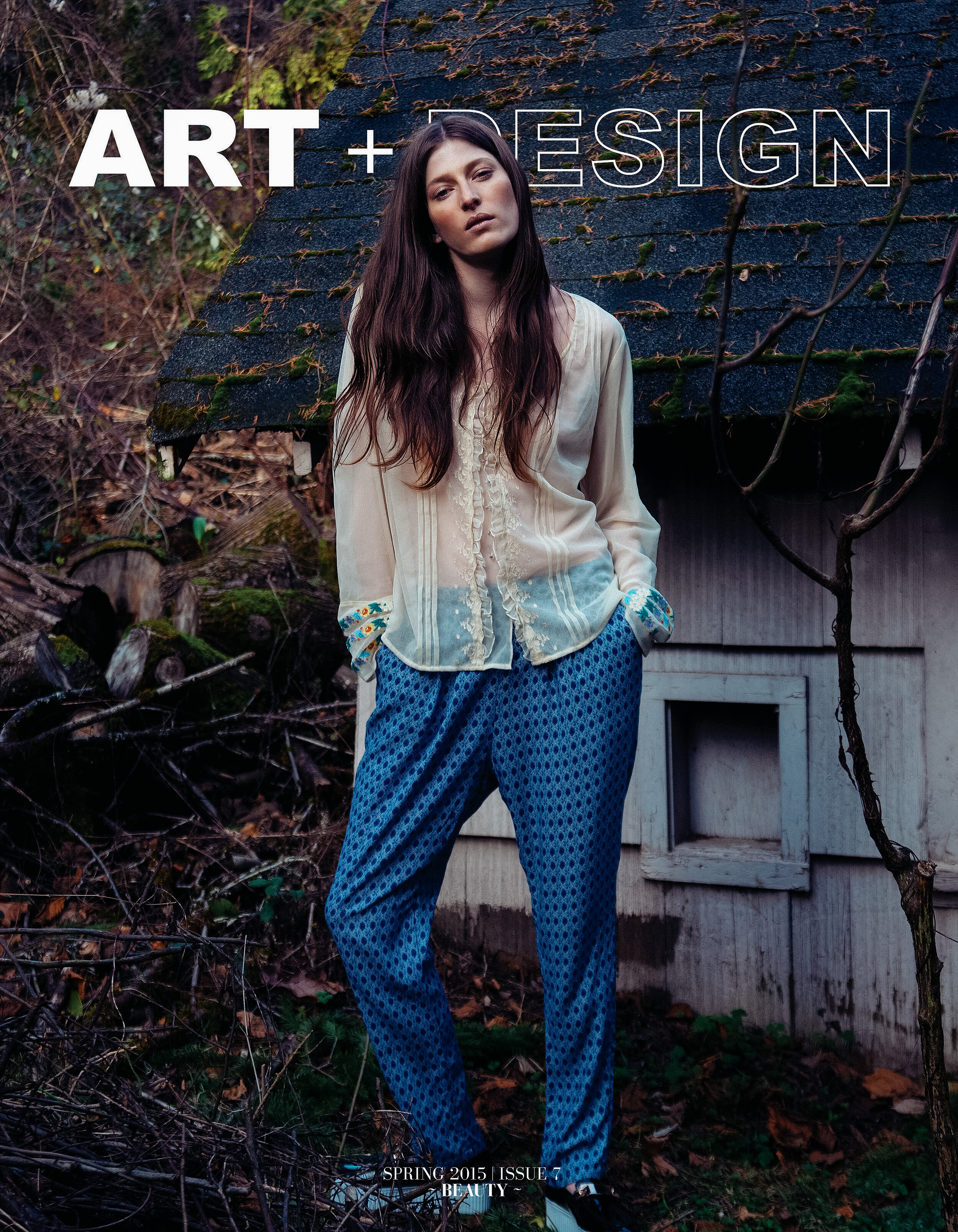 Magazine cover featuring a woman in a blouse and patterned pants posing in front of an old building in a natural setting.