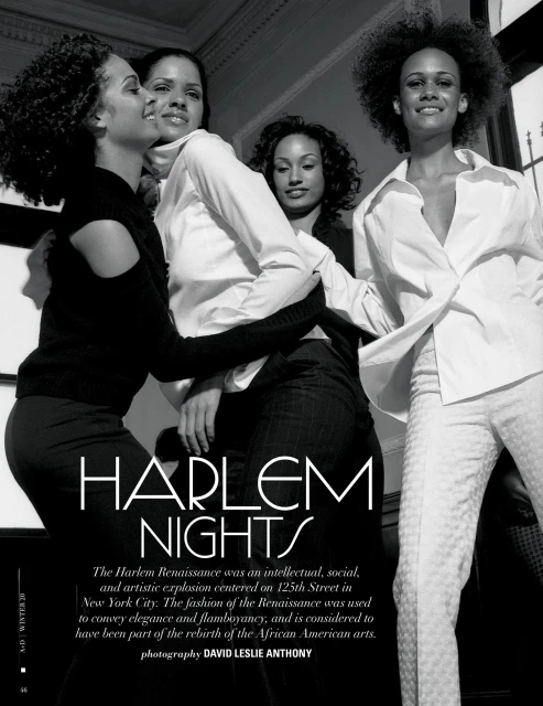 Black and white image of four African-American women in a fashion editorial, wearing white blouses and dark pants and smiling.