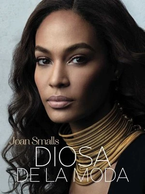 Close-up portrait of Joan Smalls on magazine cover; she has long dark hair and is wearing a multilayered gold necklace.