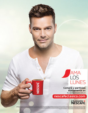 Adult male poses with red coffee mug in a promotional image with the Nescafé logo and Spanish text on a blue and cream background.