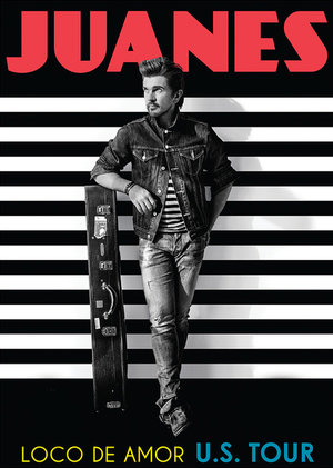 Promotional image of Juanes wearing a denim jacket, jeans, and a striped shirt while leaning against a guitar case.