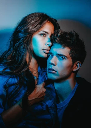 Portrait of a man and a woman close together lit by blue and warm lighting by Murad And Nataly Osmann