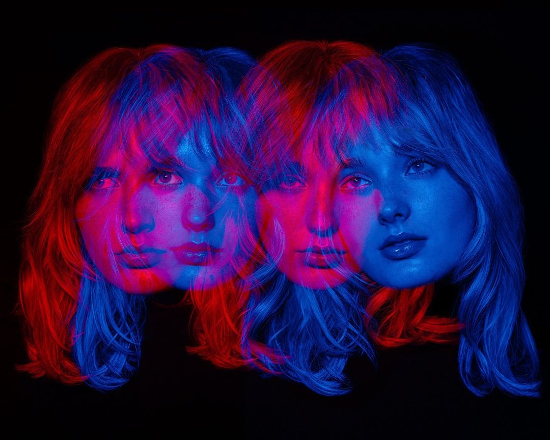 Woman's face with red and blue color grading overlapping on a dark background in a studio-style portrait, creating a layered effect.
