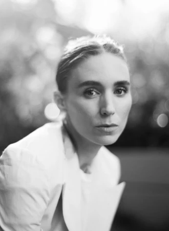Black and white close-up portrait of a woman wearing a white jacket against a softly blurred background by photographer Chantal Anderson