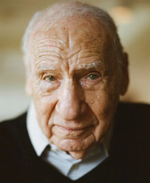 Close-up portrait of an elderly adult male with light skin wearing a dark sweater, capturing his facial details and subtle expression.