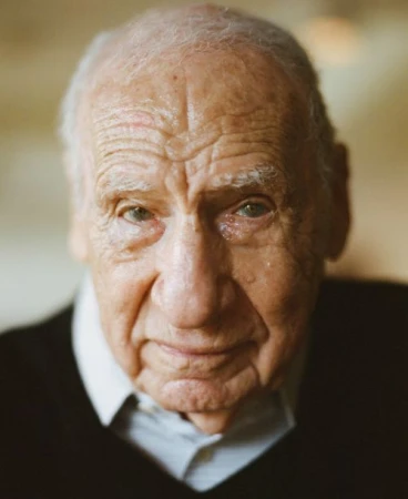 Close-up portrait of an elderly adult male with light skin wearing a dark sweater, capturing his facial details and subtle expression.