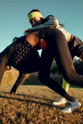 Two women exercising outdoors in a grassy park setting under warm golden hour sunlight