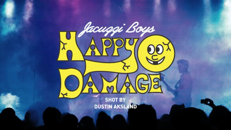 Promotional image for Jacuzzi Boys' album "Happy Damage" shows the album art, a cartoon face, against a purple stage backdrop.