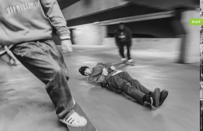 Black and white action shot of skateboarders in a concrete carpark by Dustin Aksland