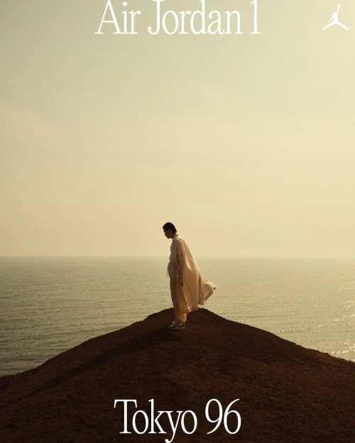 Person in flowing white clothing on a hilltop overlooking the ocean at sunset. 'Air Jordan 1' and 'Tokyo 96' text overlays.
