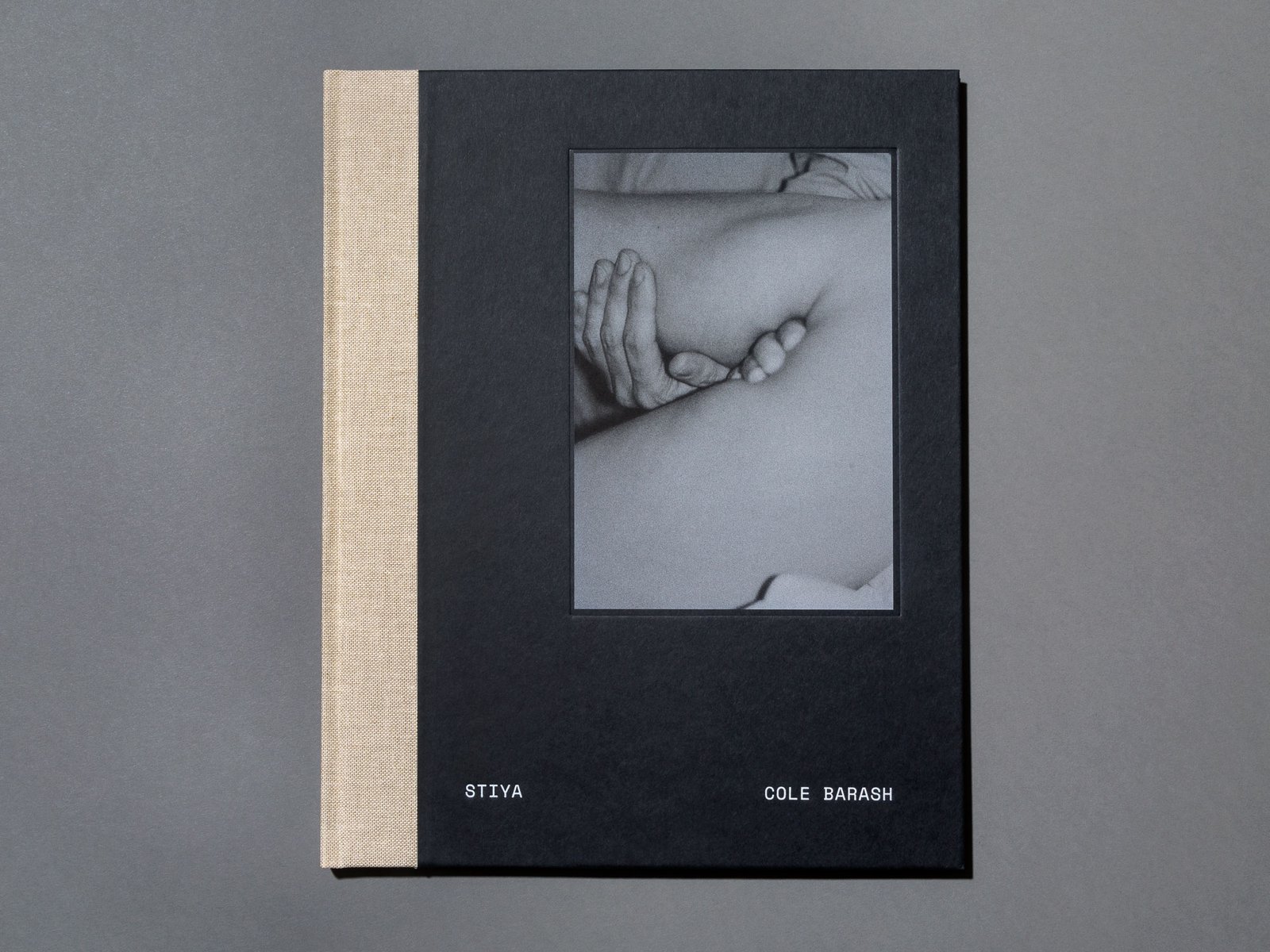 A book cover features a black and white photograph of a person's torso and hands. The book is titled 'Stiya' by Cole Barash.