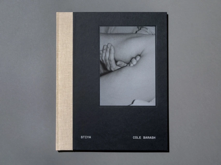A book cover features a black and white photograph of a person's torso and hands. The book is titled 'Stiya' by Cole Barash.