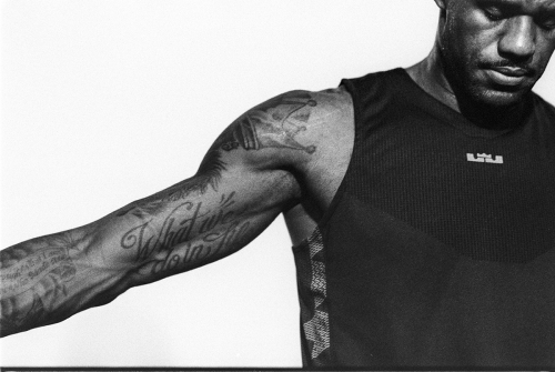 Close-up portrait of LeBron James in a black athletic tank top against a plain white background, photographed by Cole Barash.