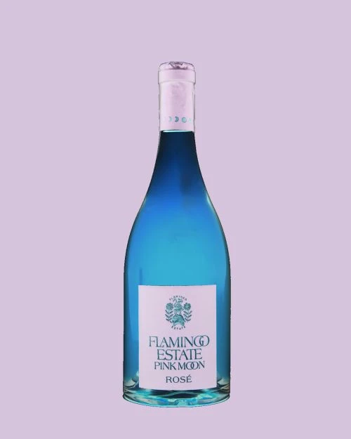 Studio shot of a cyan-colored wine bottle with a white label that reads, 'Flamingo Estate Pink Moon Rosé,' set against a lilac backdrop.