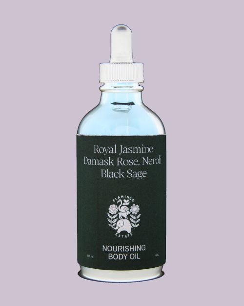 Glass bottle of body oil with white dropper cap against a plain light mauve background