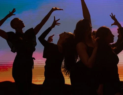 Silhouetted figures of several women in expressive poses against a colorful background, artistic lighting, dance, performance, and silhouette art.