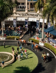 High angle shot of Gulfstream Park paddock with jockeys walking horses and spectators in stands