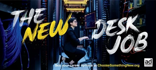 Person in server room with modern desk job ad, coding on computer. Shows computer equipment and person crouched, working, and smiling.