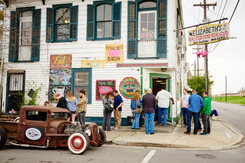 Vintage truck parked outside Elizabeth's Restaurant. People standing in front of the building. Signage visible. Outdoor scene, daytime.