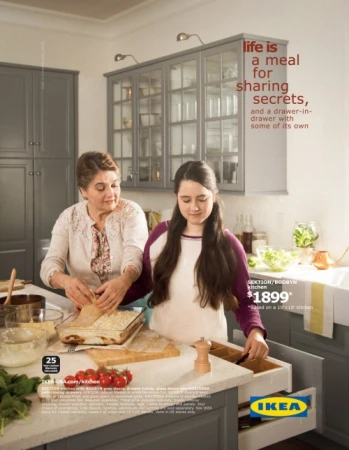 IKEA advertisement featuring two women in a gray kitchen, preparing food on a countertop with a drawer open.