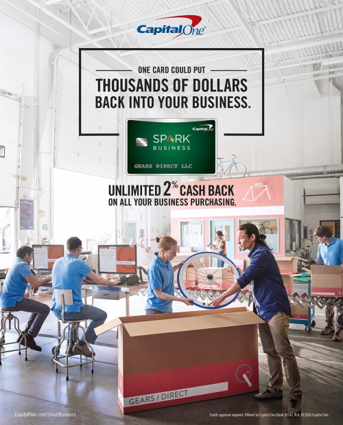 Group of diverse workers unpack and assemble bicycle parts in a warehouse-style workshop, advertises Capital One Spark Business card.