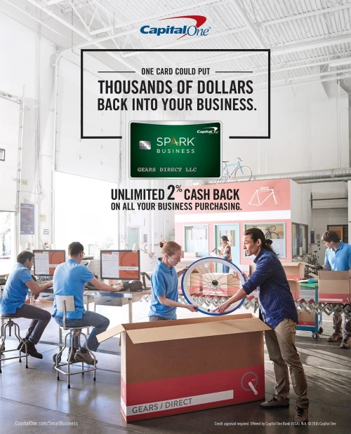 Group of diverse workers unpack and assemble bicycle parts in a warehouse-style workshop, advertises Capital One Spark Business card.