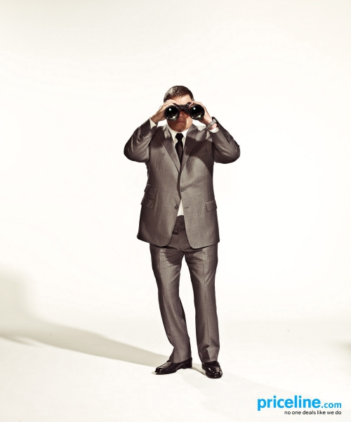 Man in a suit looking through binoculars against a plain white backdrop, promoting travel or exploration, with copy for Priceline.