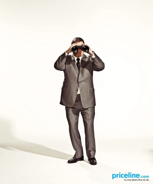 Man in a suit looking through binoculars against a plain white backdrop, promoting travel or exploration, with copy for Priceline.