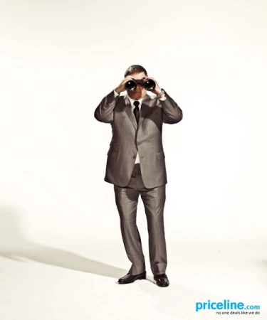 Man in a suit looking through binoculars against a plain white backdrop, promoting travel or exploration, with copy for Priceline.