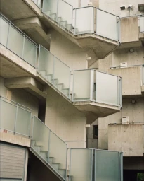 Exterior architectural view of brutalist concrete stairwells with frosted glass railings in Los Angeles.