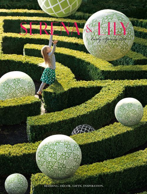 Girl reaching in a green hedge maze with floating patterned spheres. Garden setting with Serena & Lily logo. Spring home decor inspiration.
